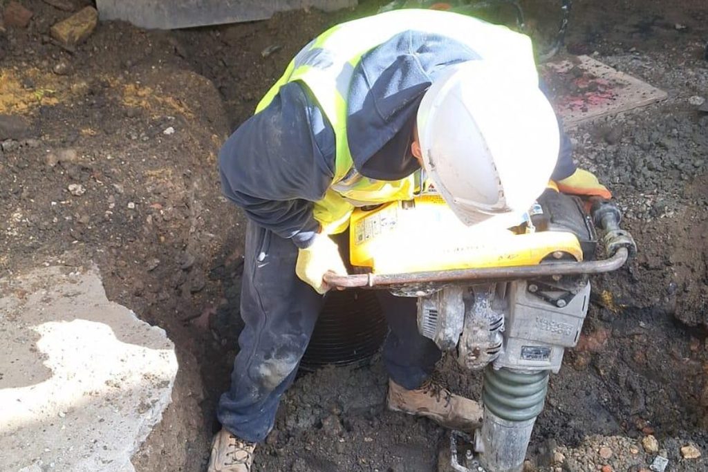 Compacting the backfill with a trench rammer, Beckenham